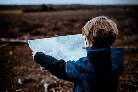 Un garçon regarde une carte et cherche un bon trajet